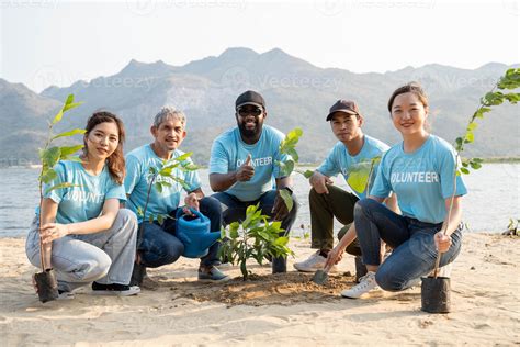 Group of volunteer smiling To Camera sitting On the beach. Protection Of Environment And Nature ...