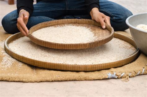 Premium Photo | Woman competitive winnowing rice by using bamboo basketwork outdoor