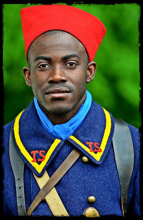 a man in uniform with a red beret on his head