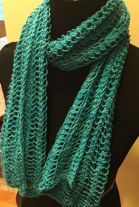 a green knitted scarf on top of a mannequin