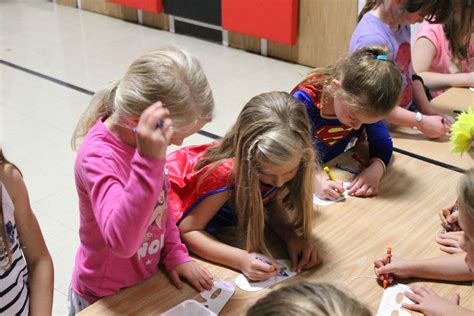 Students at Gilbert Elementary School make their own superhero masks during the school-wide ...