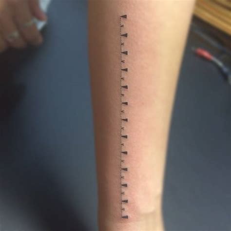 Ruler tattoo on the forearm.