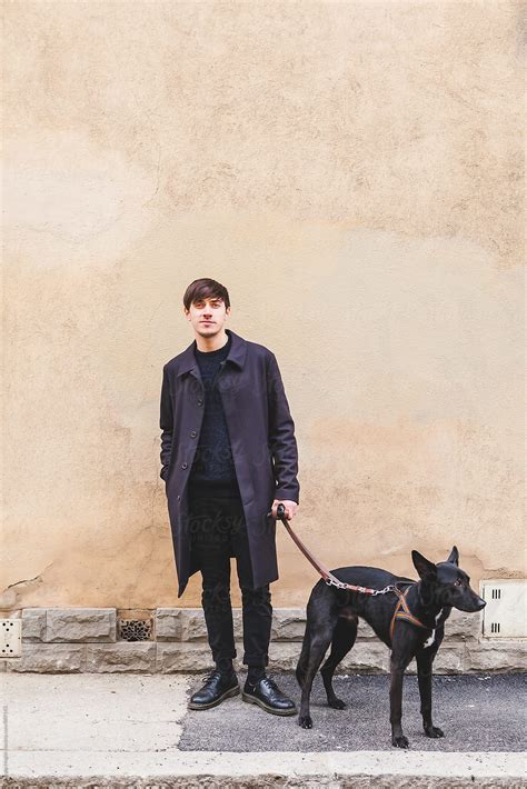 "Young Man With Black Dog Standing On A Sidewalk" by Stocksy ...