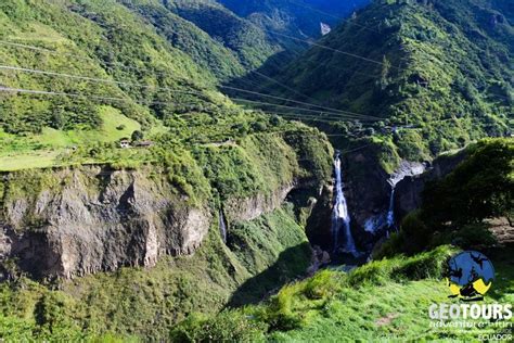 a waterfall in the mountains with power lines running down it's sides and green grass on both sides