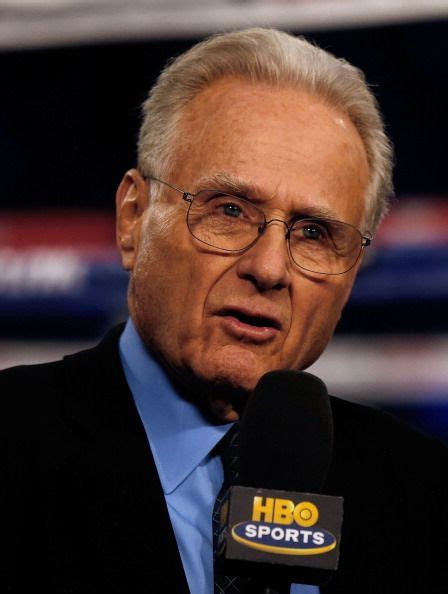 an older man wearing glasses and a suit talking into a microphone with the hbo sports logo on it