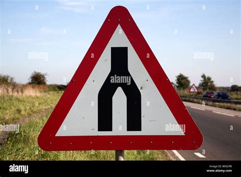 End of dual carriageway red triangular road sign Stock Photo - Alamy