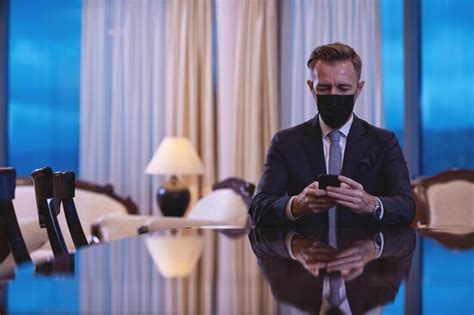 Premium Photo | Corporate business man wearing face mask and using smart phone at luxury office