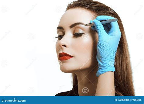 Close-up of a Young Woman Tweezing Eyebrows with Tweezers Stock Image ...