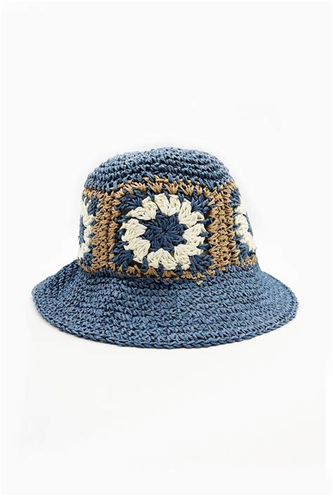 a crocheted blue hat with white and brown details on the brimming