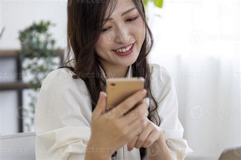 A Japanese woman checking smartphone by remote work in the small office 41677944 Stock Photo at ...