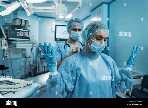 doctor helping to wear surgical uniform for surgeon Stock Photo - Alamy