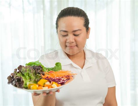 Fat woman eating salad | Stock image | Colourbox