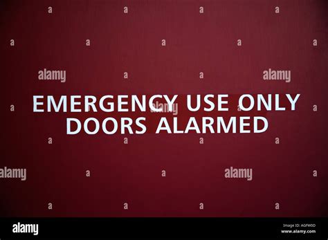 Emergency exit sign in red door Stock Photo - Alamy