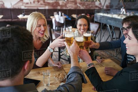 Friends toasting with beer in cafe - Stock Photo - Dissolve