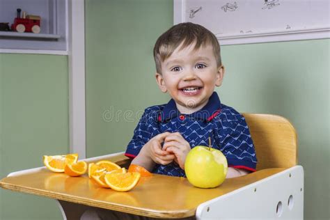 Happy toddler eating fruit stock photo. Image of kindergarden - 53445994