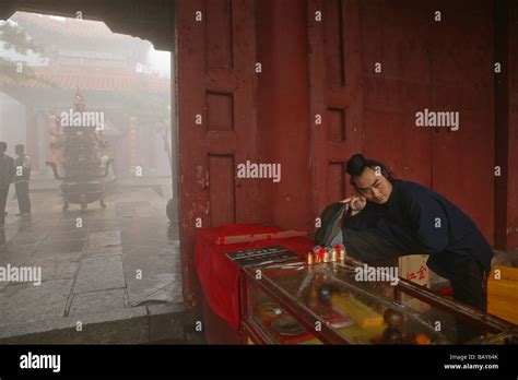 Taoist monk at the entrance to Bixia Si temple doing stretching exercises, Azure Clouds Temple ...