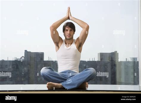 Man sitting in yoga position on floor Stock Photo - Alamy