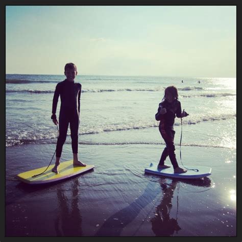 two people are standing on surfboards at the beach