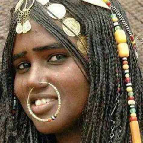 an african woman with braids and jewelry on her head is smiling at the ...