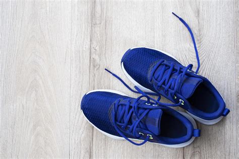 A pair of blue sneakers on a light wooden laminate. Sports theme ...