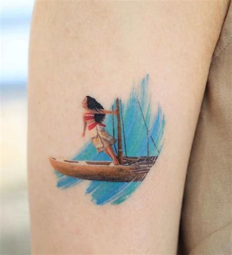 a woman riding on top of a surfboard in the ocean with a sail tattoo