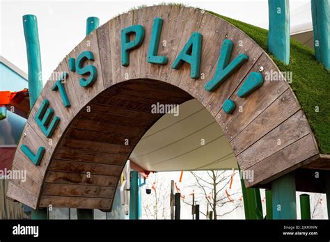 Let's Play children's playground wooden entrance sign Stock Photo - Alamy