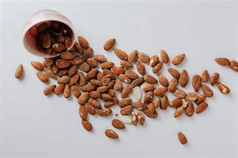 Raw almonds spilled out of small ceramic bowl · Free Stock Photo