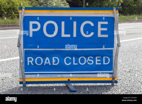 Blue Police Road Closed Sign on Tarmac Road Stock Photo - Alamy