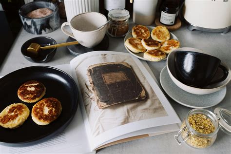 Fresh pancakes on black plate near opened book on kitchen table · Free Stock Photo