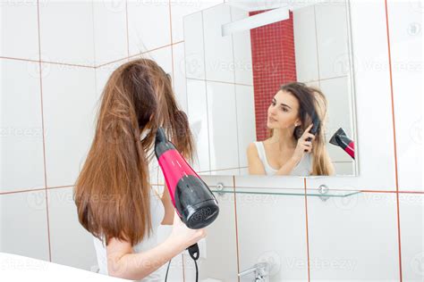 girl before the mirror dries hair 16494471 Stock Photo at Vecteezy