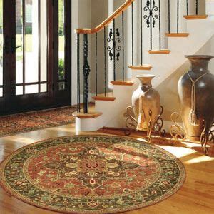 the foyer: door rug, round floor rug, vases beside the stairwell | Circular rugs, Living ...