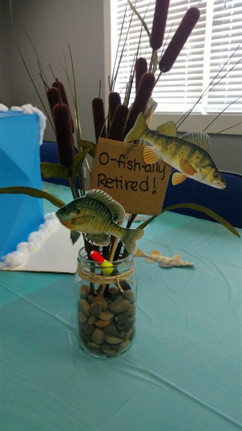 a jar filled with fish and rocks on top of a blue tablecloth covered table