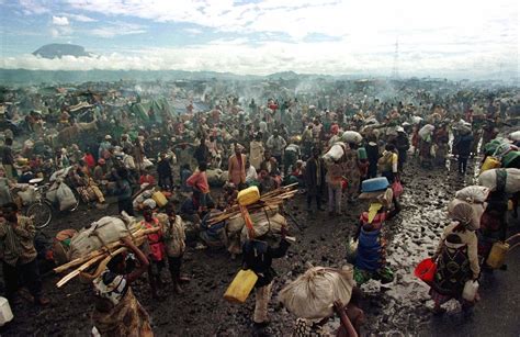 Rwandan Hutu refugees rest on the side of the road next to the old ...