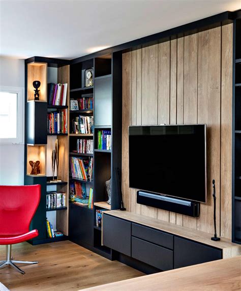 Meuble TV sur-mesure en lambris effet bois clair avec bibliothèque noire.