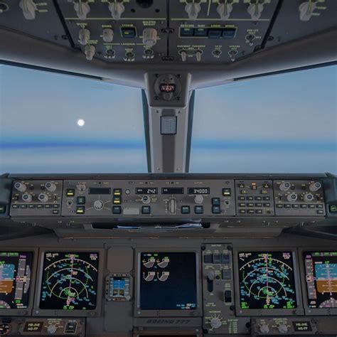 Boeing 777 cockpit. As we are cruising through the night the moon is ...