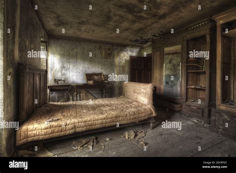 A bedroom of an abandoned house with dirty walls and broken furniture ...