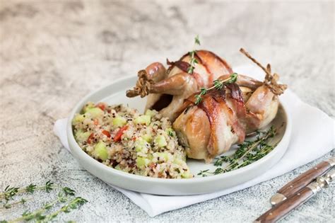 Premium Photo | Delicious baked quail with bacon and side dish