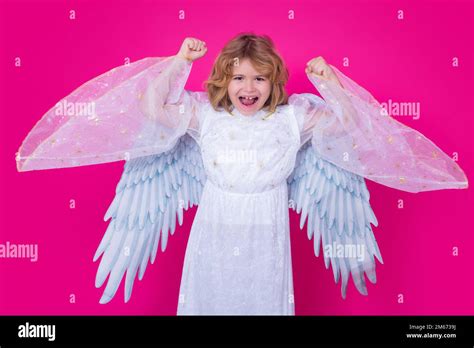 Kid wearing angel costume white dress and feather wings. Innocent child. Little angel on ...