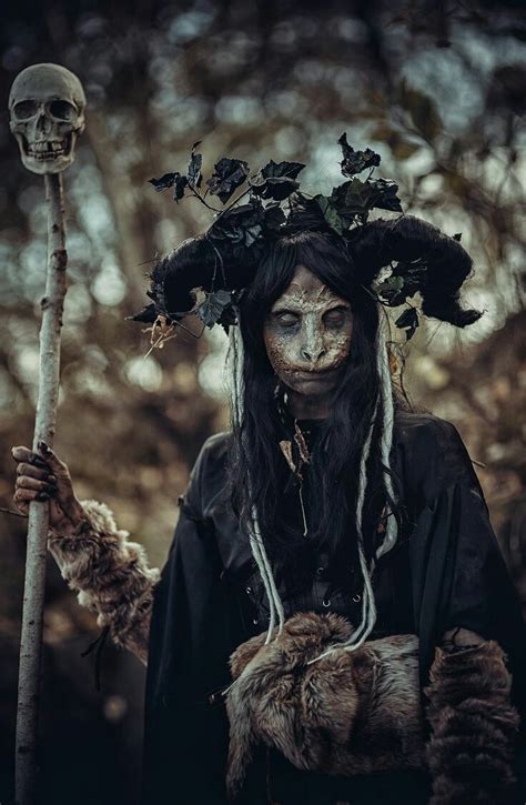 a woman dressed as a skeleton holding a stick and wearing a wreath on ...