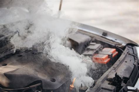 Premium Photo | The engine of the broken car is smoking Closeup