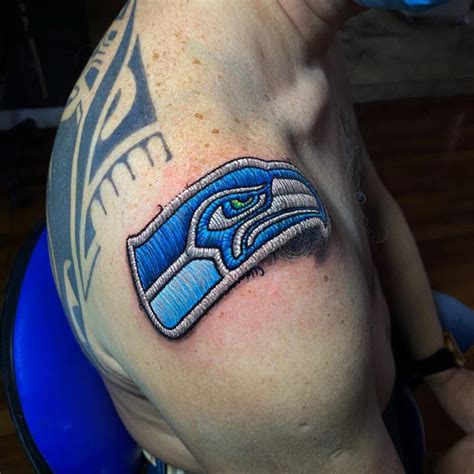 Seattle Seahawks patch tattoo located on the shoulder.