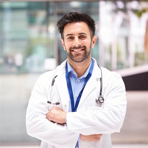 Portrait Of Male Doctor With Stethoscope Wearing White Coat Standing In Modern Hospital Building ...