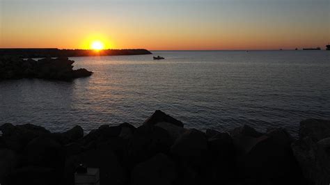 Drone Footage of People Riding in a Boat on the Sea at Sunset · Free Stock Video