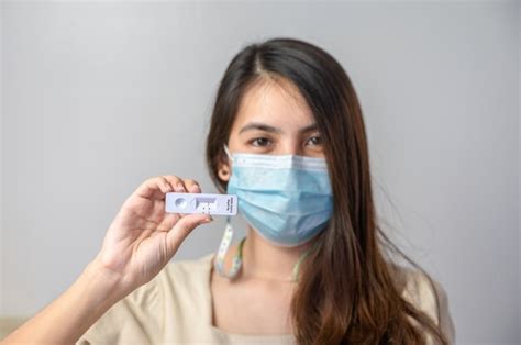 Premium Photo | Asian woman wearing face mask showing negative result of rapid antigen test kit ...