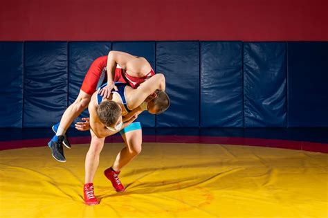 Premium Photo | Two strong wrestlers in blue and red wrestling tights are making a hip throw on ...