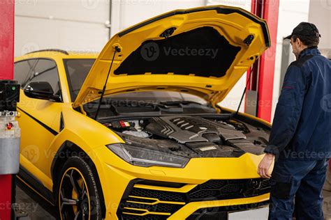 Mechanic open hood of yellow sport car suv. 14703351 Stock Photo at Vecteezy