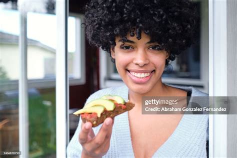 Portrait Of Young Hispanic Woman With Avocado Toast And Fresh Tomato Outside A Singlefamily Home ...
