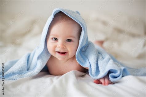 Cute little baby boy, relaxing in bed after bath, smiling happily Stock Photo | Adobe Stock