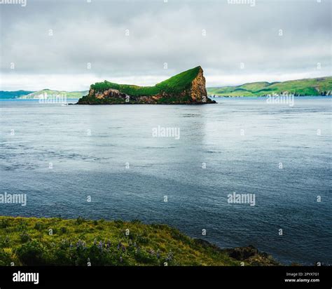 A scenic landscape featuring a small island covered with lush green grass, Umnak, Alaska Stock ...