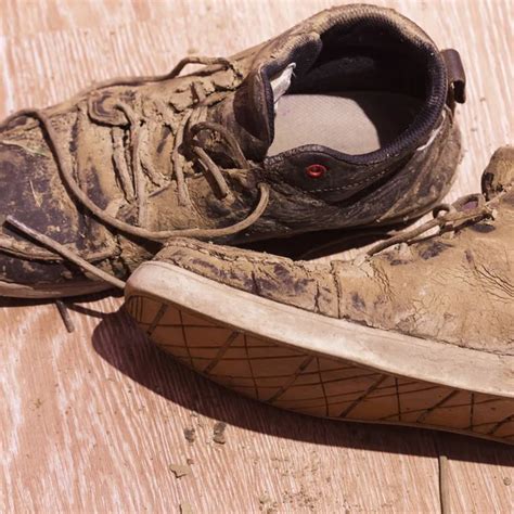 Dirty shoes with dried mud on the floor — Stock Photo © Koldunov #129295940